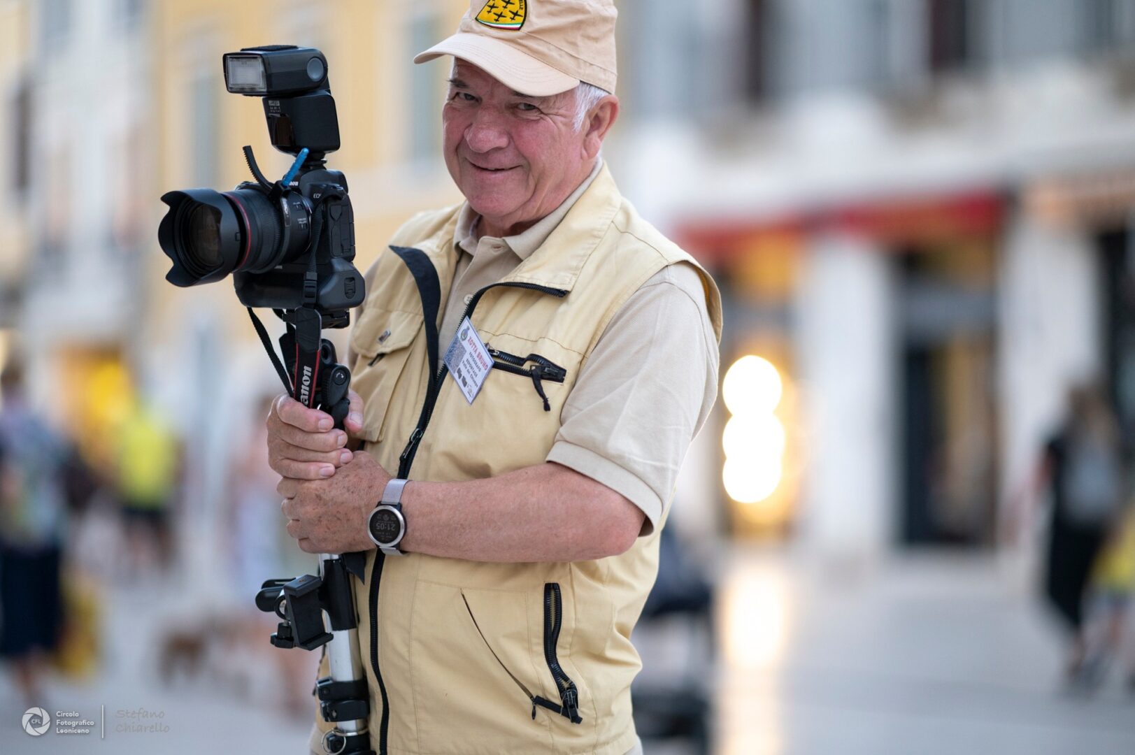 Fotografo anziano sorridente con attrezzatura fotografica